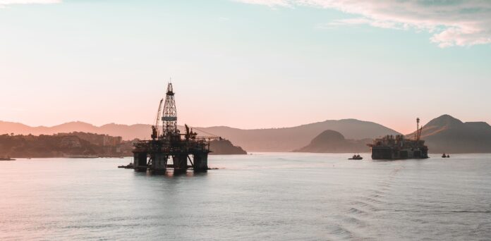 Scenic view of oil rigs at sunset. Pexels public photo by Lucas Rodrigues Vimieiro.